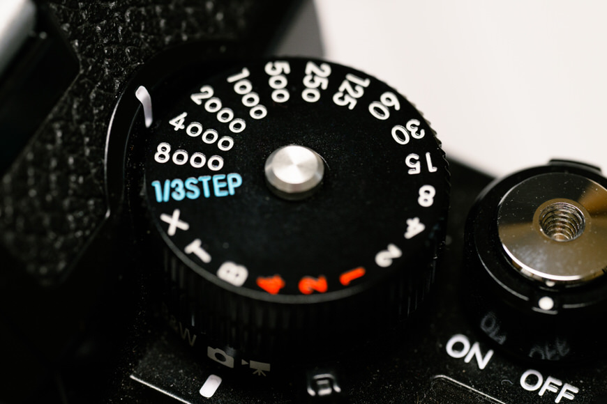 Close-up of a camera's shutter speed dial showing various settings, including numbers from 1 to 8000 and fraction steps marked "1/3 STEP.