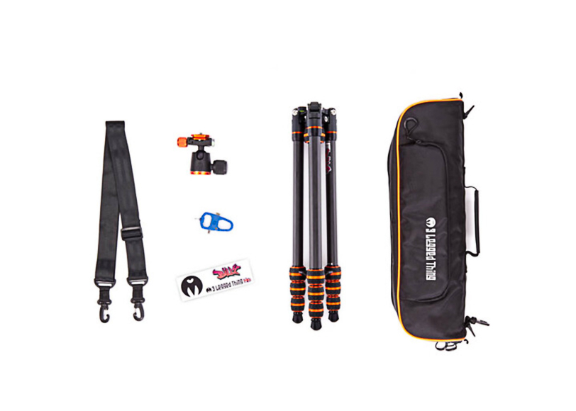 Camera tripod set with orange accents, a carrying case, head, strap, and tools arranged on a white background.