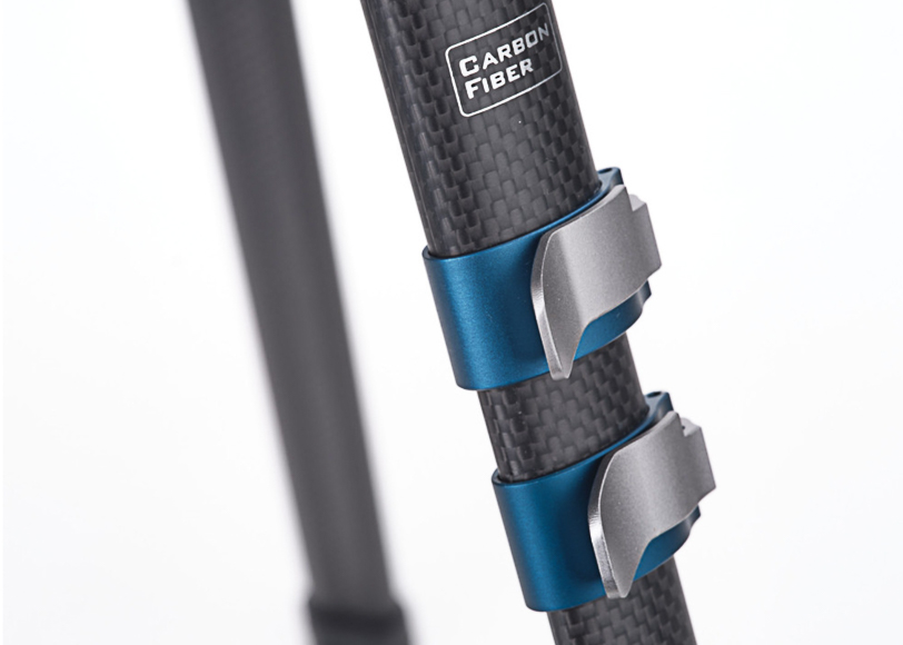 Close-up of a carbon fiber tripod leg with two blue and silver locks.