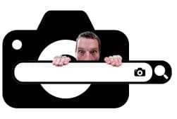A man peeks over a camera-shaped frame.