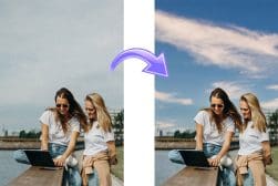 Two women sitting outdoors using a laptop. An arrow indicates a sky enhancement; the sky goes from dull to bright blue.