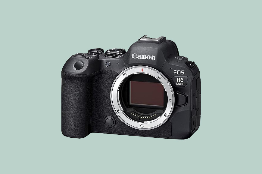 A Canon EOS R6 Mark II camera body without a lens on a light green background.