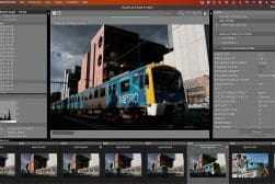 A screenshot of fujifilm x raw studio editing software showing a photo of a blue metro train passing by industrial buildings.