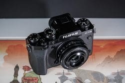 A fujifilm x-t5 camera atop a map featuring artistic renderings of landmarks.