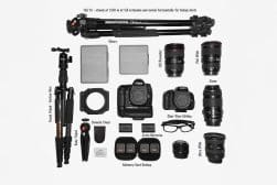 A collection of camera equipment, including two tripods, cameras, lenses, a remote timer, filters, batteries, memory cards, and a clear view editor, arranged on a light surface.