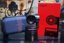 OBSBOT camera on a table with its packaging and a carrying case in the background.