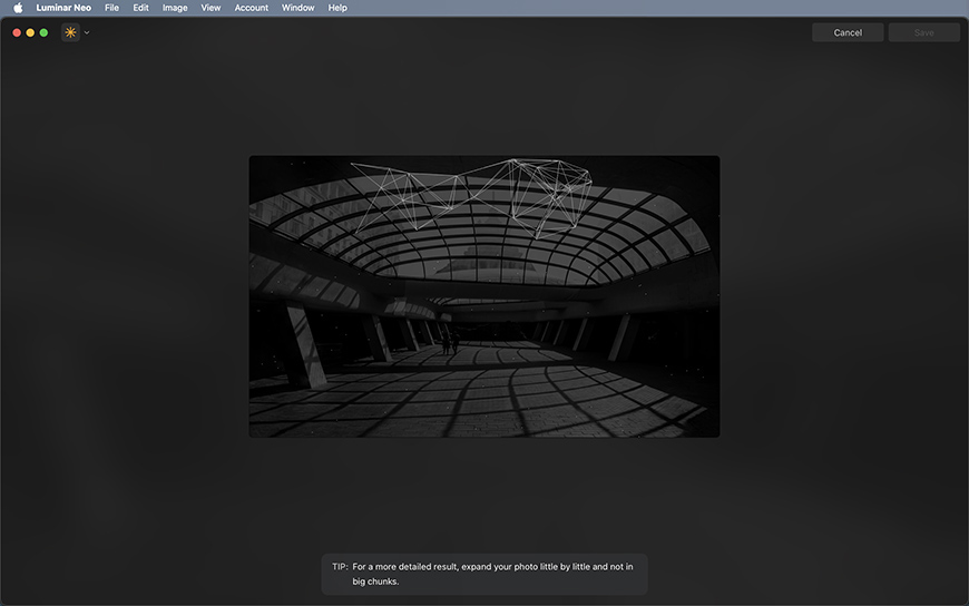 A black and white photo of a modern, curved glass roof structure with geometric patterns casting shadows on the floor.