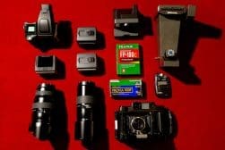 A group of cameras laying on a red surface.