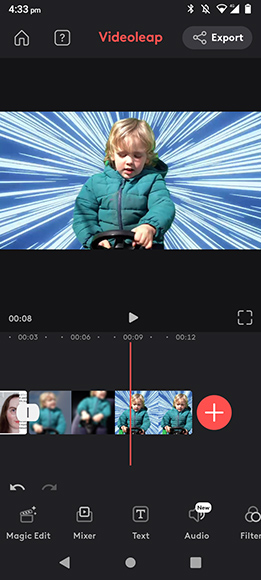 Screenshot of a mobile video editing app displaying a video of a child in a green jacket against a dynamic blue and white background. The app interface shows timeline and editing tools at the bottom.