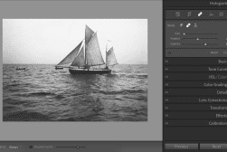 Black-and-white photo of two sailboats on the sea displayed in an image editing software's interface, showing adjustment tools on the right side of the screen.