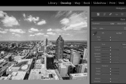 A black and white aerial photo of a city skyline is displayed in an image editing software. Editing control panels are visible on the right side of the screen.