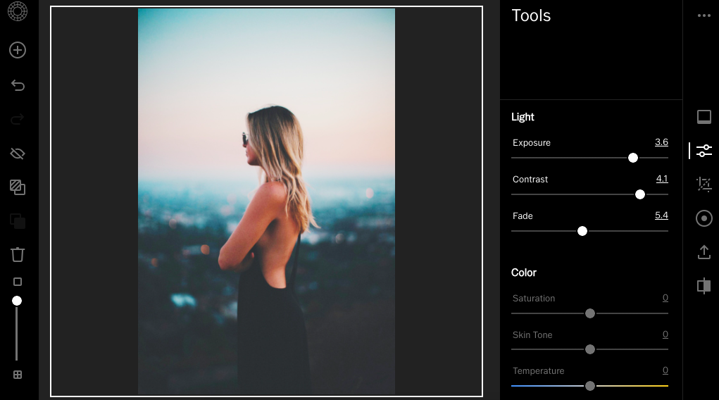 A woman with long blonde hair in a black backless dress stands with arms crossed, facing a blurred cityscape at sunset, displayed on an image editing tool interface with adjustable settings.